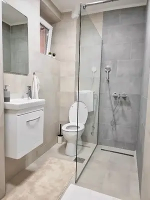 a bathroom with a toilet and a glass shower at The Blue Velvet Apartment in Belgrade