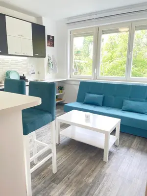a living room with a blue couch and a table at The Blue Velvet Apartment in Belgrade