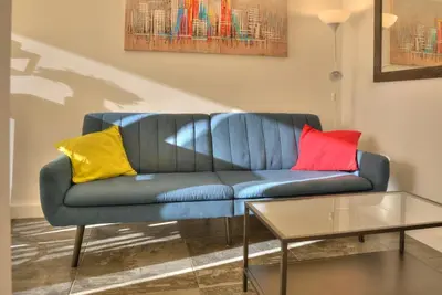 a blue couch with three colorful pillows on it at Kalemegdan Central Apartment in Belgrade