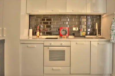 a kitchen with white cabinets and a stove top oven at Kalemegdan Central Apartment in Belgrade