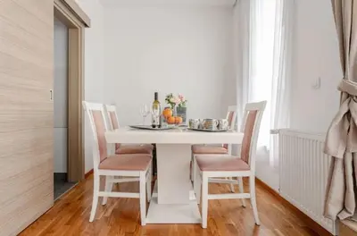 a white dining room table with chairs and a white table at Penthouse Danube Exclusive, Parking, 90m2, Wifi in Novi Grad