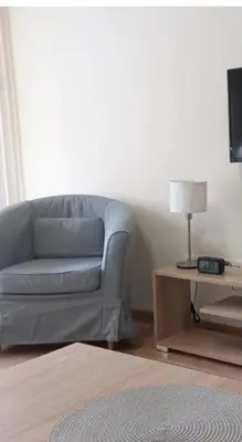 a living room with a couch and a table with a lamp at Libero 78 in Vračar (historical)