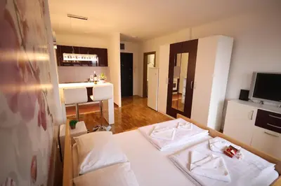 a room with two beds and a kitchen at Apartman Dana in Nova Pazova