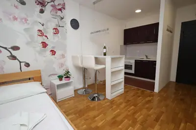 a room with a kitchen with a table and a counter at Apartman Dana in Nova Pazova