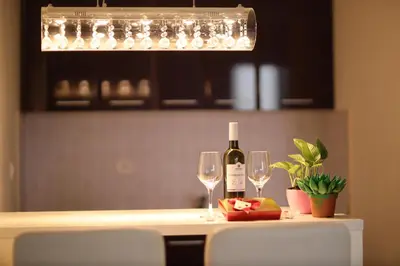a bottle of wine and two glasses on a table at Apartman Dana in Nova Pazova