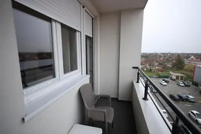 a balcony with a chair and a window at Apartman Dana in Nova Pazova