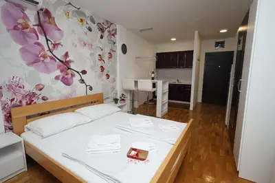 a small bedroom with a bed and a kitchen at Apartman Dana in Nova Pazova