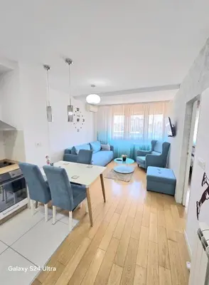 a living room with a table and blue chairs at A BLOK1 NEW BELGRADE in Novi Beograd
