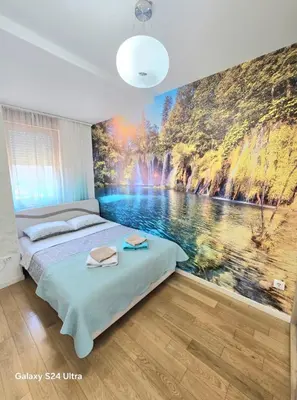 a bedroom with a large painting on the wall at A BLOK1 NEW BELGRADE in Novi Beograd