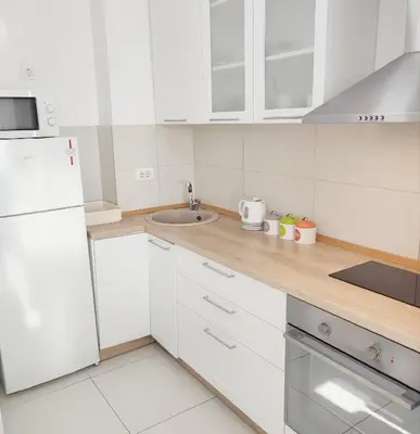 a white kitchen with a sink and a white refrigerator at A BLOK1 NEW BELGRADE in Novi Beograd