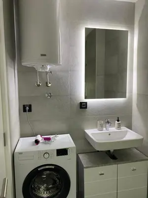 a bathroom with a washing machine and a sink at Oasis in Jajinci