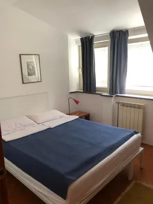 a bedroom with a bed with a blue blanket at Stan u samom centru Obrenovca, na Trgu 2 in Obrenovac
