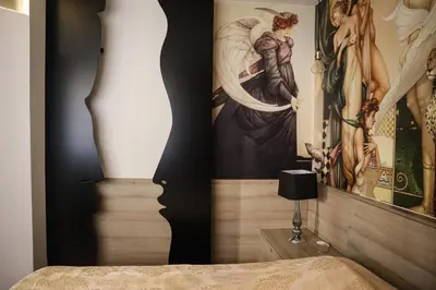 a bedroom with a painting on the wall next to a bed at The Empress apartment Belgrade in Belgrade