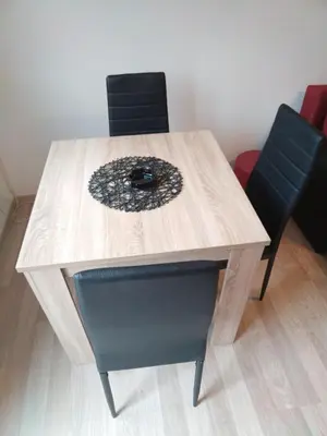 a wooden table with two black chairs around it at Cezar in Arandjelovac