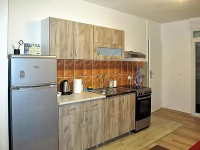 a kitchen with wooden cabinets and a stainless steel refrigerator at Cezar in Arandjelovac