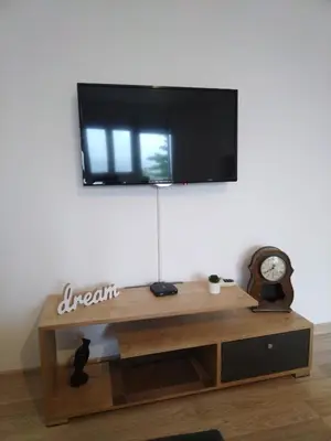 a tv on a wall above a wooden table at Cezar in Arandjelovac