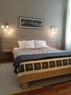 a bed with a wooden frame in a room at Evergreen in Belgrade