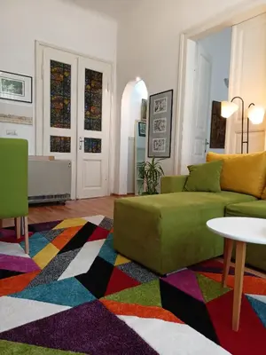 a living room with a green couch and a colorful rug at Evergreen in Belgrade