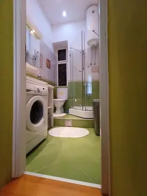 a green bathroom with a washing machine and a washer at Evergreen in Belgrade