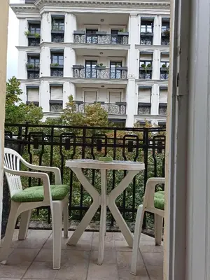 a table and chairs on a balcony with a building at Evergreen in Belgrade