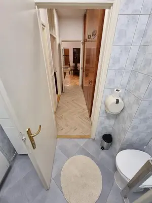 a small bathroom with a toilet and a hallway at Big Downtown Apartment across National Theater (2 Bedrooms) in Belgrade