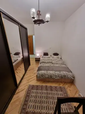 two beds in a room with a mirror at Big Downtown Apartment across National Theater (2 Bedrooms) in Belgrade