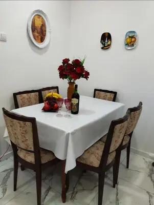 a dining room table with a white table cloth and wine bottles at Palace Luxury Apartments The Heart of Belgrade in Belgrade