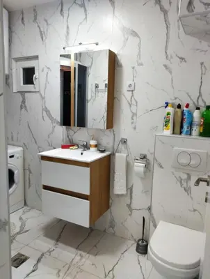 a bathroom with a sink and a toilet and a mirror at Palace Luxury Apartments The Heart of Belgrade in Belgrade