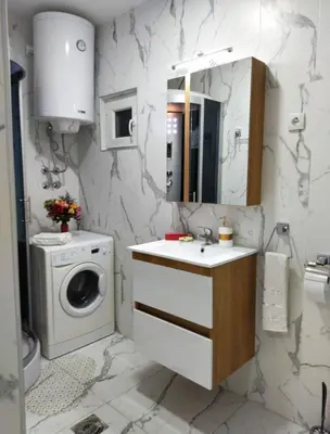 a bathroom with a sink and a washing machine at Palace Luxury Apartments The Heart of Belgrade in Belgrade