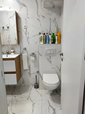 a white bathroom with a toilet and a sink at Palace Luxury Apartments The Heart of Belgrade in Belgrade