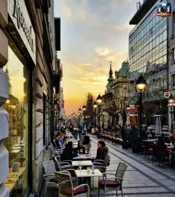 a group of people sitting at tables on a city street at Palace Luxury Apartments The Heart of Belgrade in Belgrade
