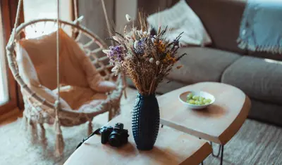 a vase with flowers on a table in a living room at Rent a Forest, Cabin Hidden in the Fruška gora in Velika Remeta