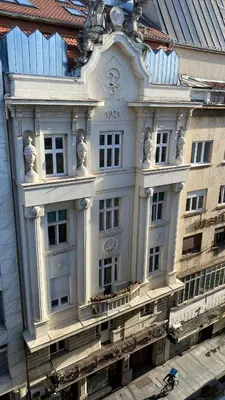 a white building with statues on the side of it at DOM Boutique Apartments OLD TOWN in Belgrade