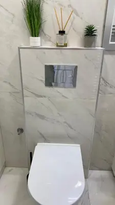a white toilet in a bathroom with marble walls at DOM Boutique Apartments OLD TOWN in Belgrade