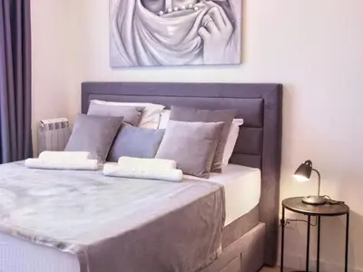 a bedroom with a large bed with a painting on the wall at BW Aurora 108 in Belgrade