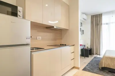a kitchen with white cabinets and a refrigerator at BW Aurora 108 in Belgrade