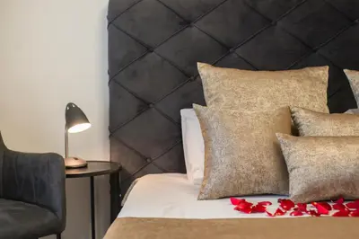 a bed with a black headboard with red flowers on it at BW Aurora 108 in Belgrade