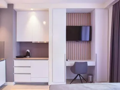 a bedroom with a bed and a desk with a television at BW Aurora 108 in Belgrade