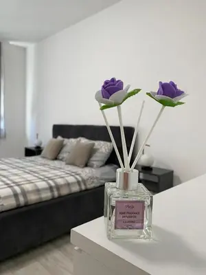 two purple flowers in a bottle on a table at Grand Royal in Belgrade