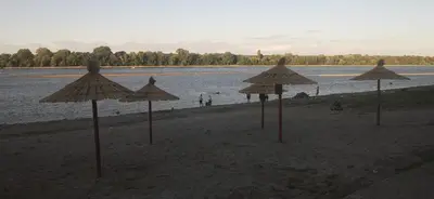a group of umbrellas on a beach near the water at Smokvica in Stari Slankamen