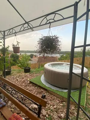 a hot tub in a garden with a bench at Smokvica in Stari Slankamen