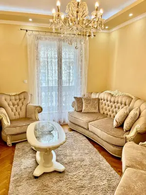a living room with a couch and a table and a chandelier at Belgrade heart of a historical center in Belgrade