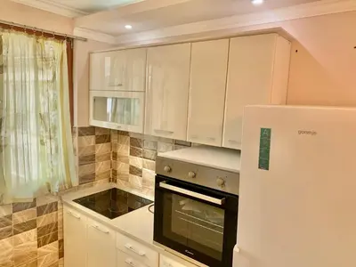 a kitchen with white cabinets and a refrigerator at Belgrade heart of a historical center in Belgrade