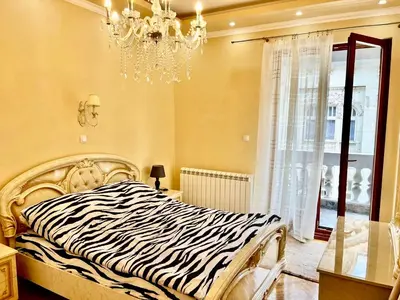 a zebra print bed in a bedroom with a chandelier at Belgrade heart of a historical center in Belgrade
