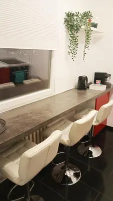 a bar with white chairs and a wooden table at Milan in Belgrade