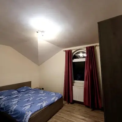 a bedroom with a bed and a window with red curtains at MARIJA sa besplatnim parkingom in Novi Beograd