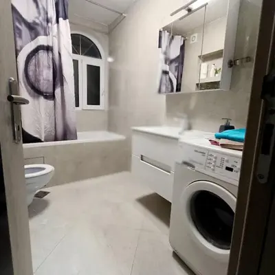 a bathroom with a washing machine and a toilet at MARIJA sa besplatnim parkingom in Novi Beograd
