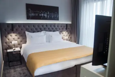 a hotel room with a large bed and a television at H41 Luxury Suites in Belgrade