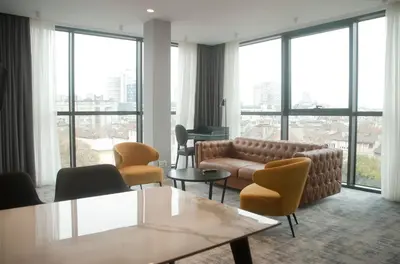 a living room with a couch and chairs and windows at H41 Luxury Suites in Belgrade