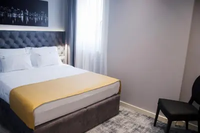 a bedroom with a large bed and a chair at H41 Luxury Suites in Belgrade